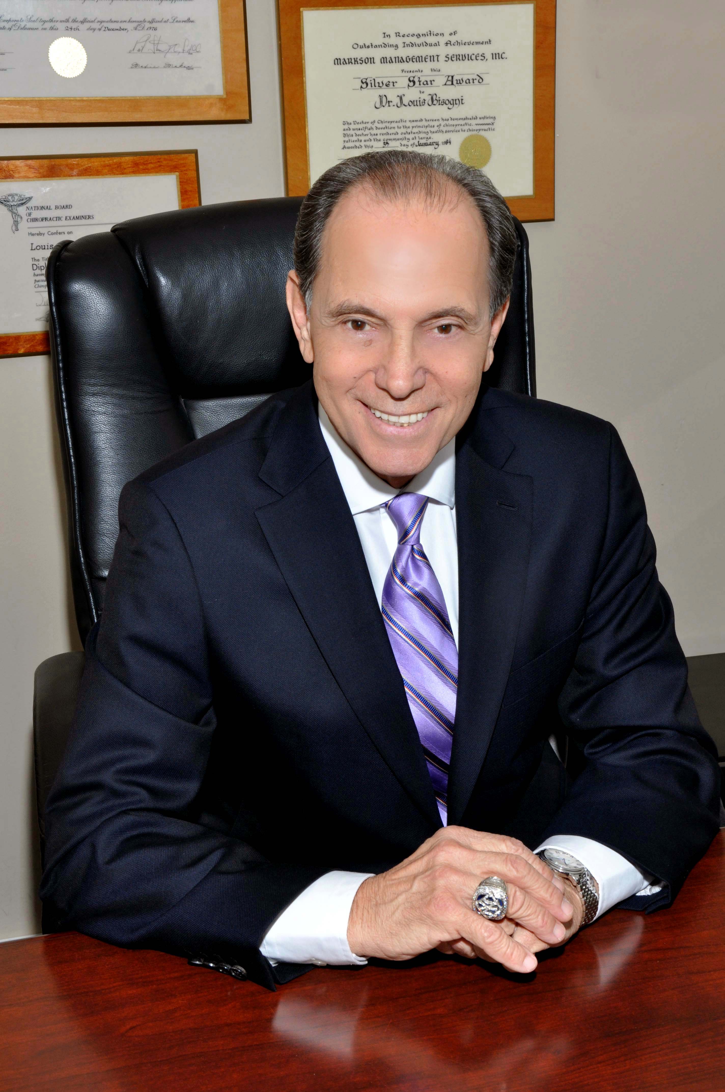 Dr. Louis Bisogni behind his desk.