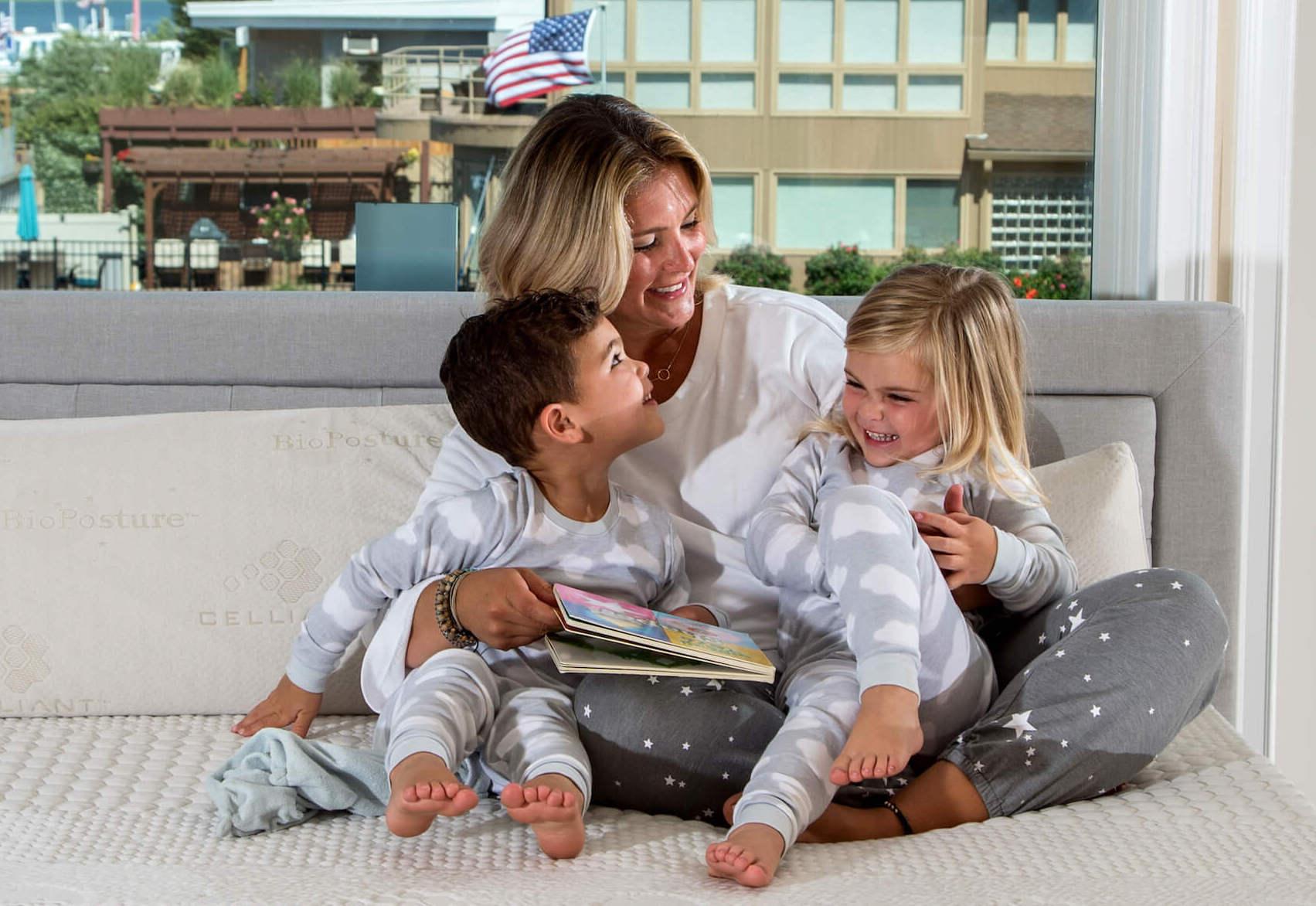 mom reading to her kids on a bed